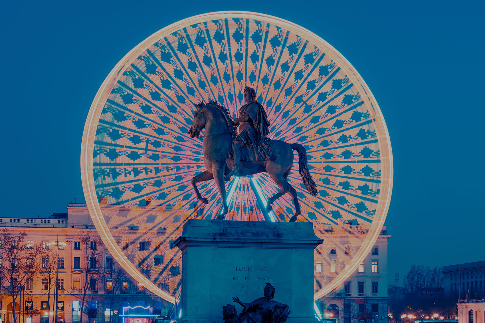 photo de la place Bellecour à lyon montrant la grande roue avec la statue d'un cavalier au premier plan