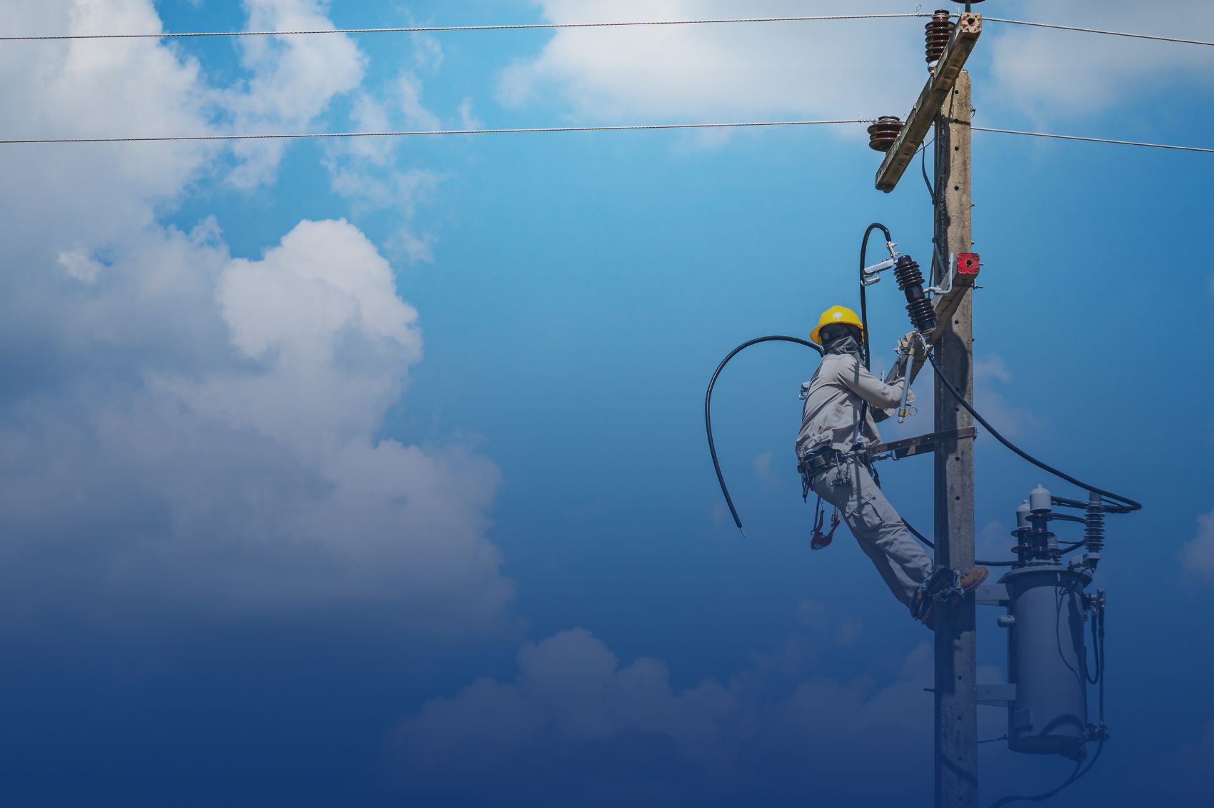 Technicien du réseau électrique sur un poteau de ligne à haute tension