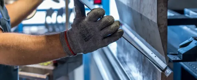 Homme manipulant une plaque d'aluminium dans une usine