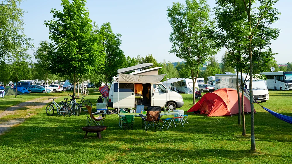 Camping-car et tentes plantées dans un camping